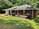 Beautiful brick home with black shutters and a manicured lawn, set against a wooded backdrop at 7400 Little Fawn Pkwy, Palmetto, GA 30268