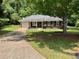 Charming single-story brick home featuring a well-maintained lawn and a paved driveway at 7400 Little Fawn Pkwy, Palmetto, GA 30268