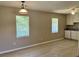 Bright, open-concept area with natural light and wood-look floors adjoined to kitchen with white cabinets at 7400 Little Fawn Pkwy, Palmetto, GA 30268