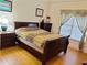 A cozy bedroom features hardwood floors, a comfortable bed, a bedside table, and natural light through window at 2905 Olde Town Park Dr, Norcross, GA 30071