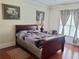 Cozy bedroom featuring hardwood floors, a comfortable bed, and soft natural light at 2905 Olde Town Park Dr, Norcross, GA 30071