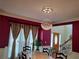 Dining room with chandelier, dark red walls, large windows, and space for large table at 2905 Olde Town Park Dr, Norcross, GA 30071