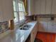 Bright kitchen featuring white cabinets, stone countertops, stainless steel sink, and a mosaic backsplash at 2905 Olde Town Park Dr, Norcross, GA 30071
