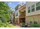 Multi-story townhome exterior with balconies surrounded by lush greenery at 2969 Rivergreen Se Ln # 23, Atlanta, GA 30339