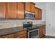 Close up of kitchen features stainless steel appliances, wood cabinets, and granite countertops at 3014 Liberty Nw Way, Atlanta, GA 30318
