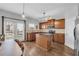 Open kitchen boasts stainless appliances, wood cabinets, an island, and hardwood floors at 3014 Liberty Nw Way, Atlanta, GA 30318