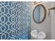 Modern powder room features patterned wallpaper, a round mirror, and a stylish pedestal sink at 3014 Liberty Nw Way, Atlanta, GA 30318