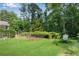 The backyard has green grass, some trees, a storage shed, and fenced in garden at 435 Old Holly Rd, Milton, GA 30075