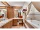 Bathroom featuring a jacuzzi tub, vanity area, hardwood floors, and neutral tile work at 435 Old Holly Rd, Milton, GA 30075
