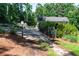 Scenic property entrance with secure gate, mature landscaping, and convenient mailbox access at 435 Old Holly Rd, Milton, GA 30075