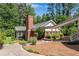 Well-maintained exterior with a brick chimney and a cozy screened-in porch, complemented by lush landscaping at 435 Old Holly Rd, Milton, GA 30075