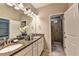 Bathroom with double vanity, granite counters, and tiled floor, with a glass-door shower and white cabinets at 711 Topsail Ln, Alpharetta, GA 30005