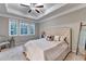 Bright bedroom featuring neutral walls, plush carpeting, tray ceiling, and large windows offering natural light at 711 Topsail Ln, Alpharetta, GA 30005