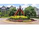 Beautifully landscaped community entrance featuring colorful flowerbeds, manicured shrubs, and a unique metal art structure at 711 Topsail Ln, Alpharetta, GA 30005