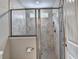 Tiled shower stall with glass door and tiled floor. Shower includes window, seat, and showerhead at 711 Topsail Ln, Alpharetta, GA 30005