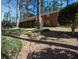 Exterior view of a brick home featuring a wooden deck and staircase in a lush backyard setting at 1288 Skyview Sw Cir, Mableton, GA 30126