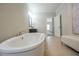 Bright bathroom featuring a soaking tub, modern vanity, and open doorway at 5836 Sandy Springs Cir, Atlanta, GA 30328