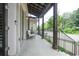 Inviting covered front porch with brick flooring, wood beams, and stylish seating area at 5836 Sandy Springs Cir, Atlanta, GA 30328