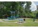 Fun community playground featuring swings, slides, and picnic tables, surrounded by lush greenery and shady trees at 5836 Sandy Springs Cir, Atlanta, GA 30328