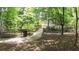 Scenic view of a tree-lined walking path with a charming bridge over a stream, perfect for nature lovers at 5836 Sandy Springs Cir, Atlanta, GA 30328