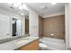 Well-lit bathroom featuring a granite countertop vanity, toilet, and tiled shower over tub at 860 Peachtree Ne St # 1912, Atlanta, GA 30308