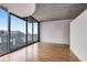 Bright living room with large windows, hardwood floors, and a view of the city skyline at 860 Peachtree Ne St # 1912, Atlanta, GA 30308