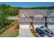 Brick townhome featuring a two-car garage, driveway, and manicured lawn in a serene setting at 2378 Morgan Creek Rd, Buford, GA 30519