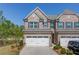 Attractive two-story brick townhome with a two-car garage, well-maintained landscaping, and black shutters at 2378 Morgan Creek Rd, Buford, GA 30519
