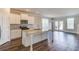 Open kitchen featuring granite countertops, an island, modern stainless steel appliances, and wood-look floors at 2378 Morgan Creek Rd, Buford, GA 30519