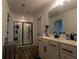 Bathroom featuring wood flooring, large mirror, double-sink vanity and glass enclosed shower at 4098 Haleston Rd, Duluth, GA 30097