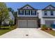 Two-story townhome featuring a stone veneer, double garage and manicured landscaping at 4098 Haleston Rd, Duluth, GA 30097