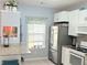 Bright kitchen area with white cabinetry and stainless steel refrigerator at 4172 Howell Park Road, Duluth, GA 30096