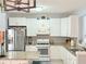 Well-lit kitchen with white cabinets, granite countertops, and stainless steel appliances at 4172 Howell Park Road, Duluth, GA 30096