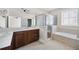 Bright bathroom featuring double vanity, soaking tub, and glass shower with tile surround at 6459 Chariot St # 35, Atlanta, GA 30328