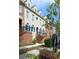 Townhome facade with blue shutters, brick entry stairs, and mature landscaping on a sunny day at 6459 Chariot St # 35, Atlanta, GA 30328