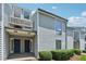 Inviting townhome exterior with gray siding, blue doors, and well-maintained landscaping at 1023 Riverbend Club Se Dr, Atlanta, GA 30339