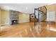 Inviting living room with a stone fireplace, hardwood floors, spiral staircase, and partial kitchen view at 1023 Riverbend Club Se Dr, Atlanta, GA 30339