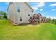 Well-maintained backyard featuring green grass, deck with stairs, and partial fence at 2090 Beckham St, Cumming, GA 30041