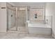Bathroom featuring a shower, large soaking tub, and window for natural light at 2090 Beckham St, Cumming, GA 30041