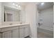 Bathroom with a double vanity, white cabinets, and a tiled shower and bath at 2090 Beckham St, Cumming, GA 30041