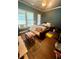 Bedroom featuring a futon, hardwood floors, and bright natural light streaming through the windows at 2961 River Ridge Drive Sw, Atlanta, GA 30354