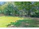 The backyard has a spacious lawn lined with mature trees and a wood fence at 1797 Emerson Lake Cir, Snellville, GA 30078