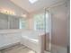 Bright bathroom featuring a large tub, frosted shower and a white vanity at 1797 Emerson Lake Cir, Snellville, GA 30078