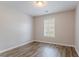 An empty bedroom with laminate flooring and a window with blinds for natural light at 1797 Emerson Lake Cir, Snellville, GA 30078
