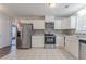 Well-lit kitchen featuring stainless steel appliances, tile backsplash, and ample white cabinetry at 1797 Emerson Lake Cir, Snellville, GA 30078