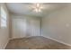 Spacious bedroom with plush carpet, a ceiling fan, and dual closets for storage at 2783 Bicentennial Dr, Stone Mountain, GA 30087
