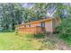 Back exterior featuring a wood deck overlooking a grassy yard surrounded by mature trees at 2783 Bicentennial Dr, Stone Mountain, GA 30087