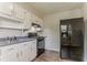 This kitchen features white cabinets, black appliances, and sleek wood flooring at 2783 Bicentennial Dr, Stone Mountain, GA 30087