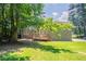 View of backyard with a wood deck and green grass surrounded by large trees, creating a private outdoor space at 2957 Temple Johnson Rd, Snellville, GA 30039