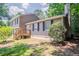 Charming two-story home featuring beige siding, black shutters, and a cozy wood deck in a lush, wooded setting at 2957 Temple Johnson Rd, Snellville, GA 30039